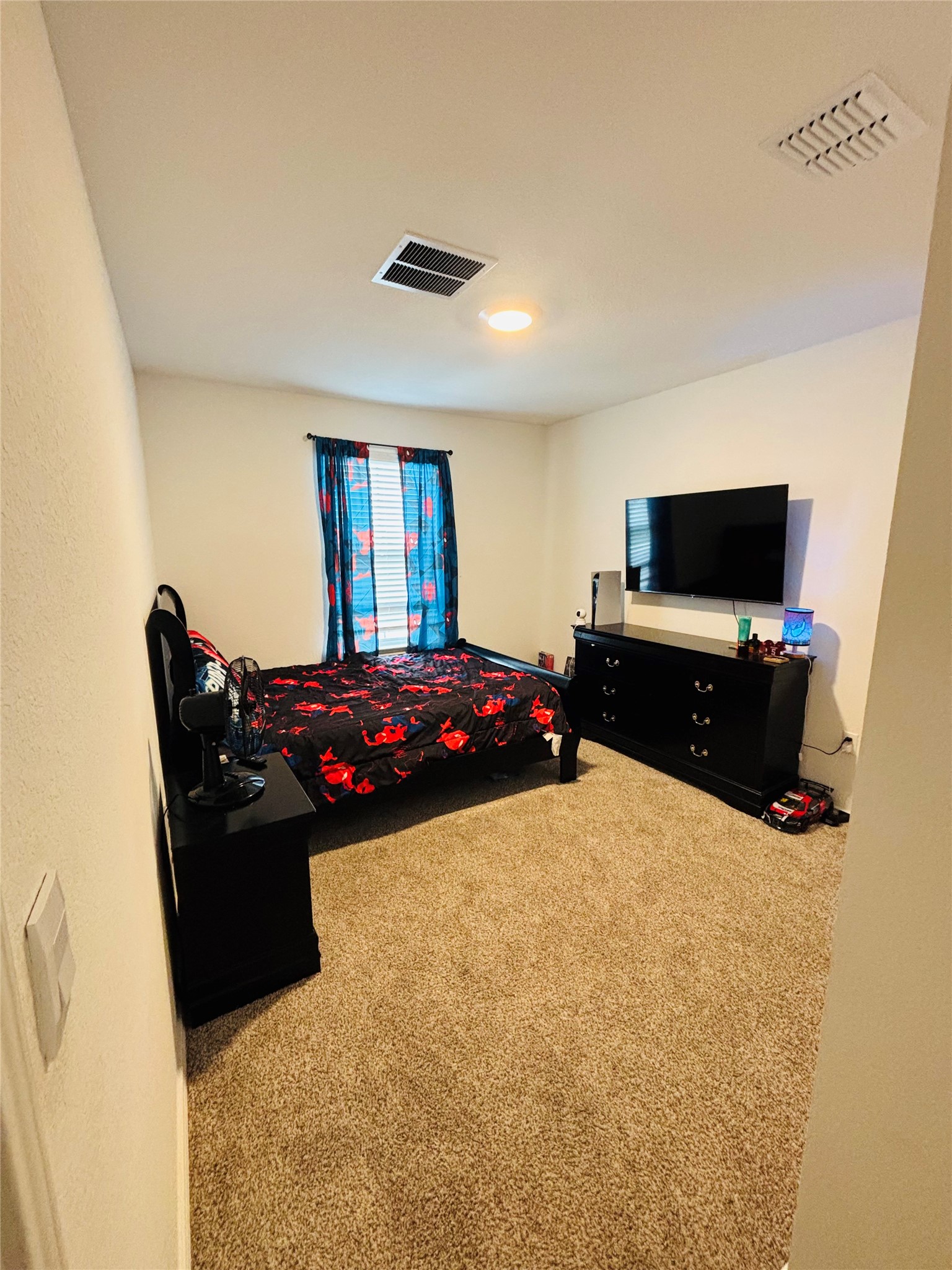14817 Perlino Way, Unit A Manor, TX 78653 - Photo 12 of 40 a bedroom with a bed and a flat screen tv