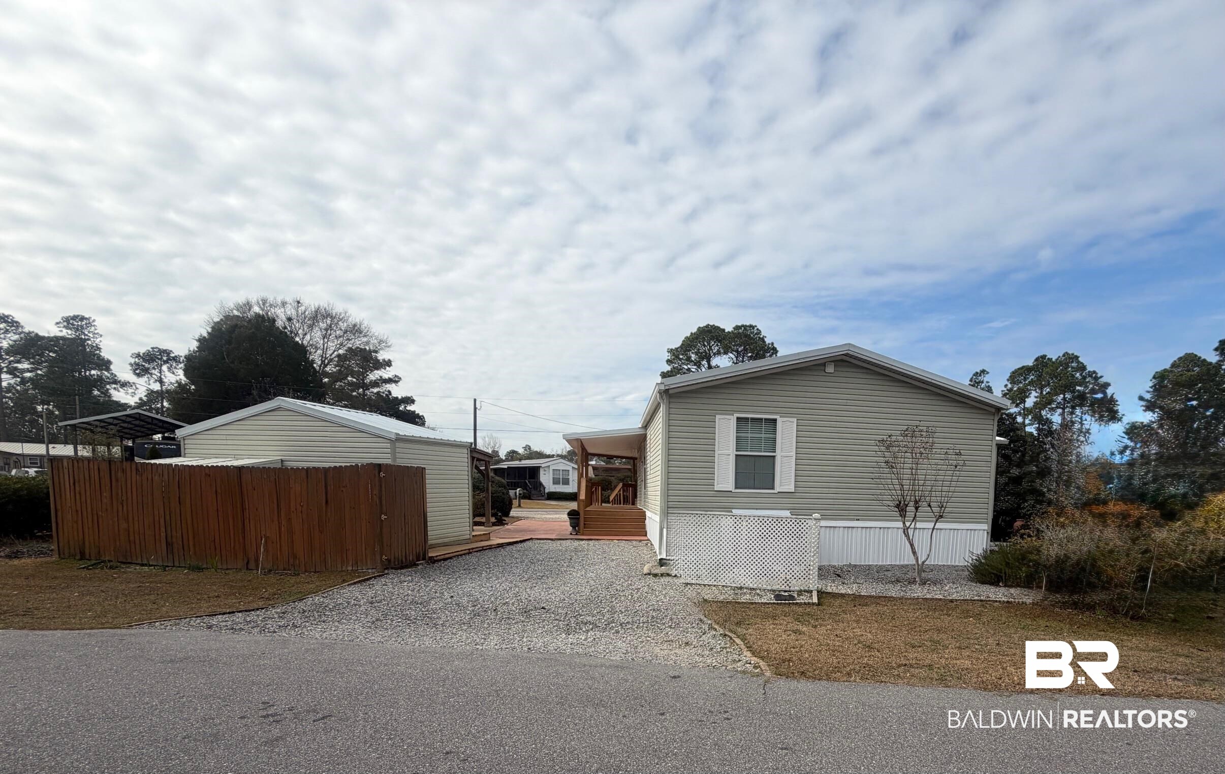 675 Escambia Loop Lillian, AL 36549 - Photo 23 of 44 View of side of property featuring a wooden deck and gravel driveway