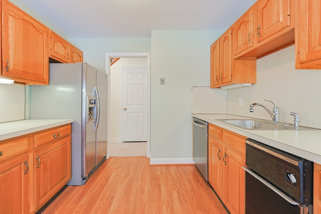 17 Quisset Brook Road, Unit 17 Milton, MA 02186 - Photo 16 of 40 a kitchen with stainless steel appliances granite countertop a refrigerator a sink dishwasher and wooden cabinets with wooden floor