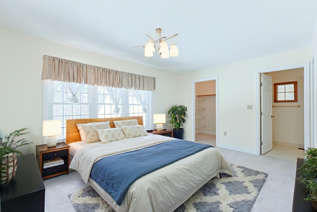 17 Quisset Brook Road, Unit 17 Milton, MA 02186 - Photo 8 of 40 a bedroom with a large bed and a chandelier