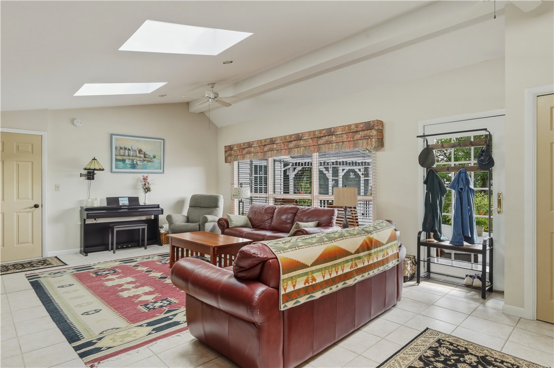 Family Room offers natural light from the skylights, a raised ceiling, and tile flooring.
