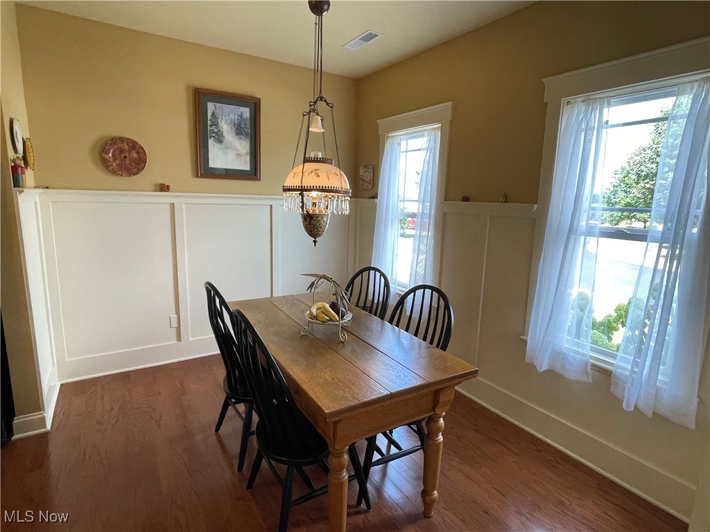 8322 Forest Ridge Street Northwest Massillon, OH 44646 - Photo 11 of 33 Dining room with a decorative wall, dark wood-type flooring, and wainscoting