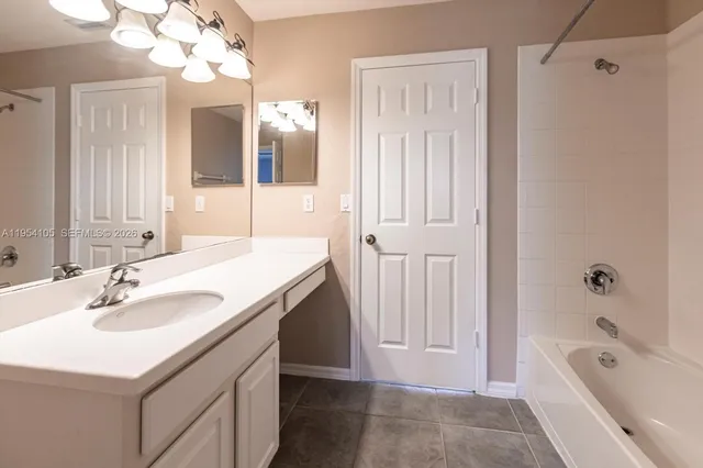 a bathroom with a tub a sink and a mirror