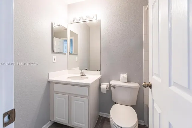 a bathroom with a toilet a sink and mirror