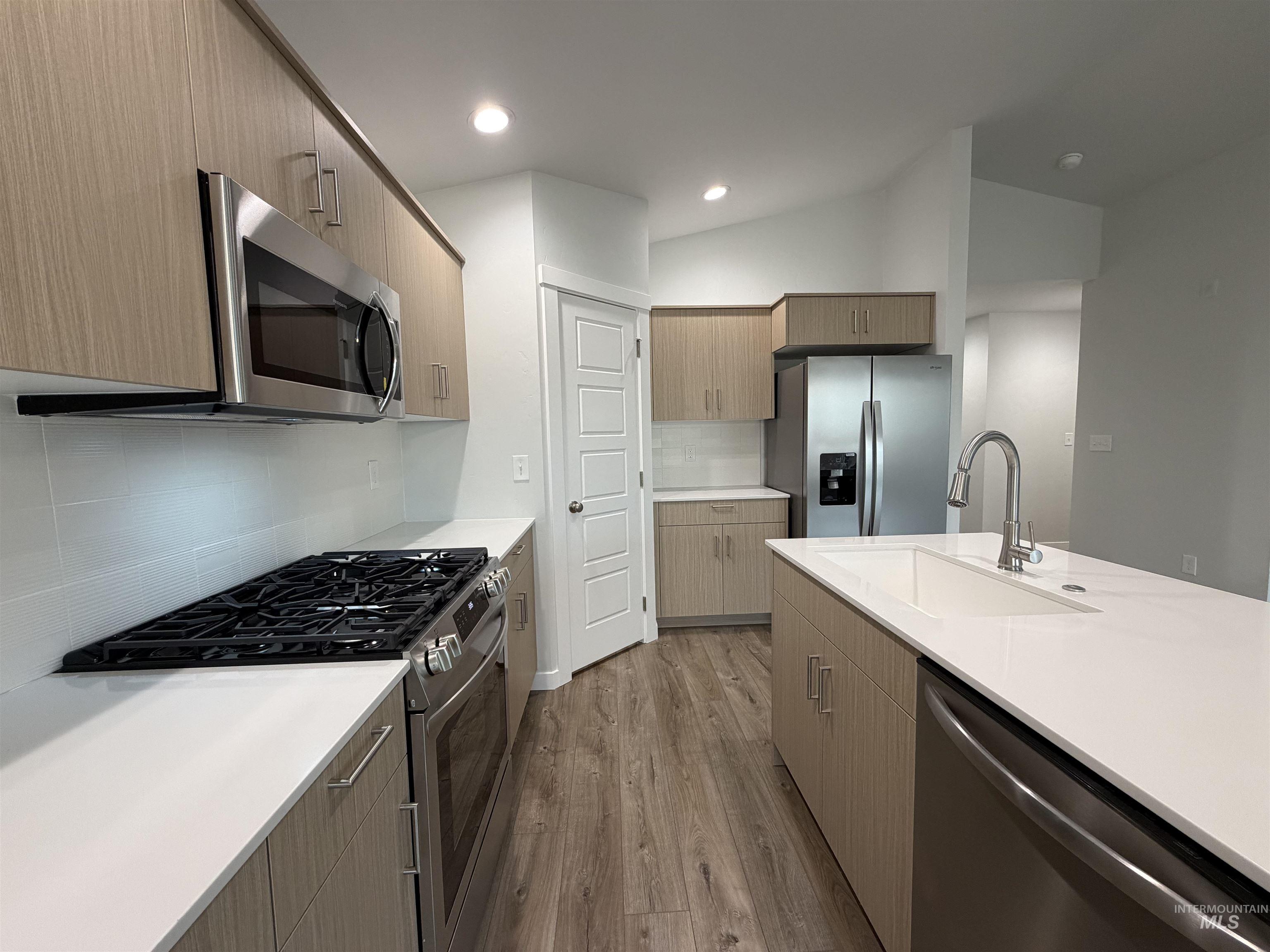 10550 West Tinder Street Star, ID 83669 - Photo 5 of 18 Kitchen with appliances with stainless steel finishes, dark wood-type flooring, tasteful backsplash, modern cabinets, and lofted ceiling