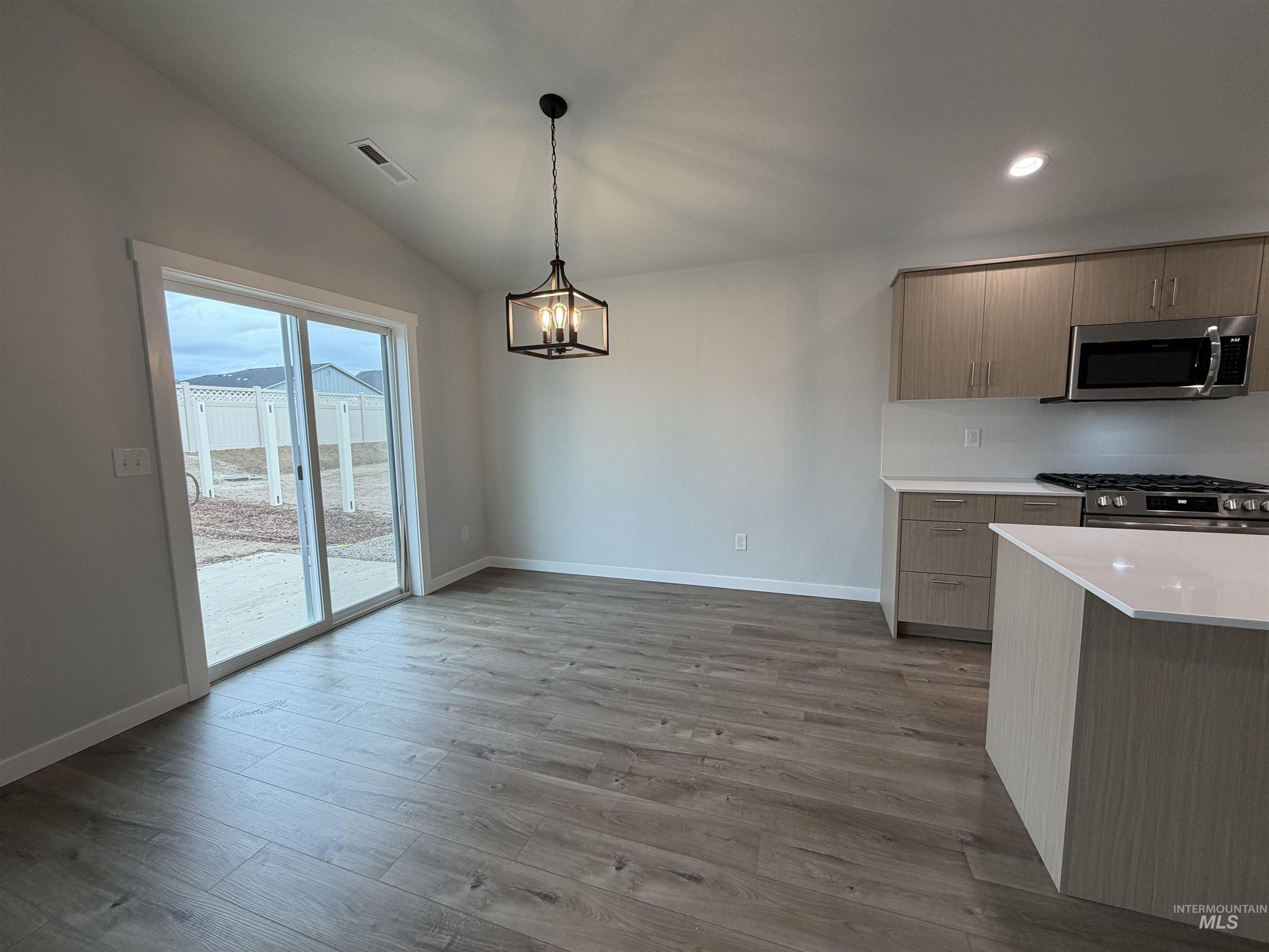 10550 West Tinder Street Star, ID 83669 - Photo 7 of 18 Kitchen featuring stainless steel appliances, pendant lighting, dark wood-type flooring, modern cabinets, and a chandelier