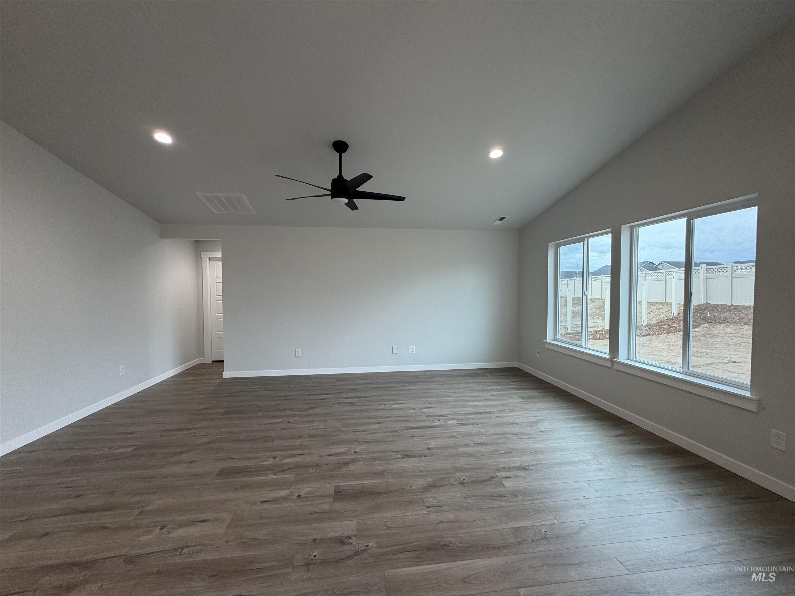 10550 West Tinder Street Star, ID 83669 - Photo 9 of 18 Empty room featuring vaulted ceiling, dark wood finished floors, recessed lighting, and ceiling fan