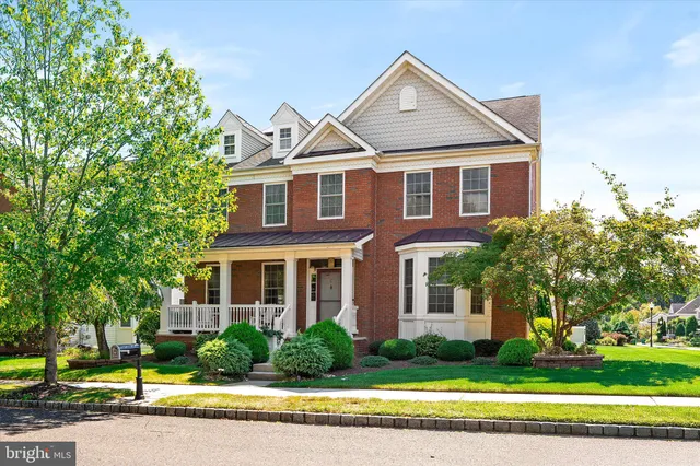 a front view of a house with a yard and trees