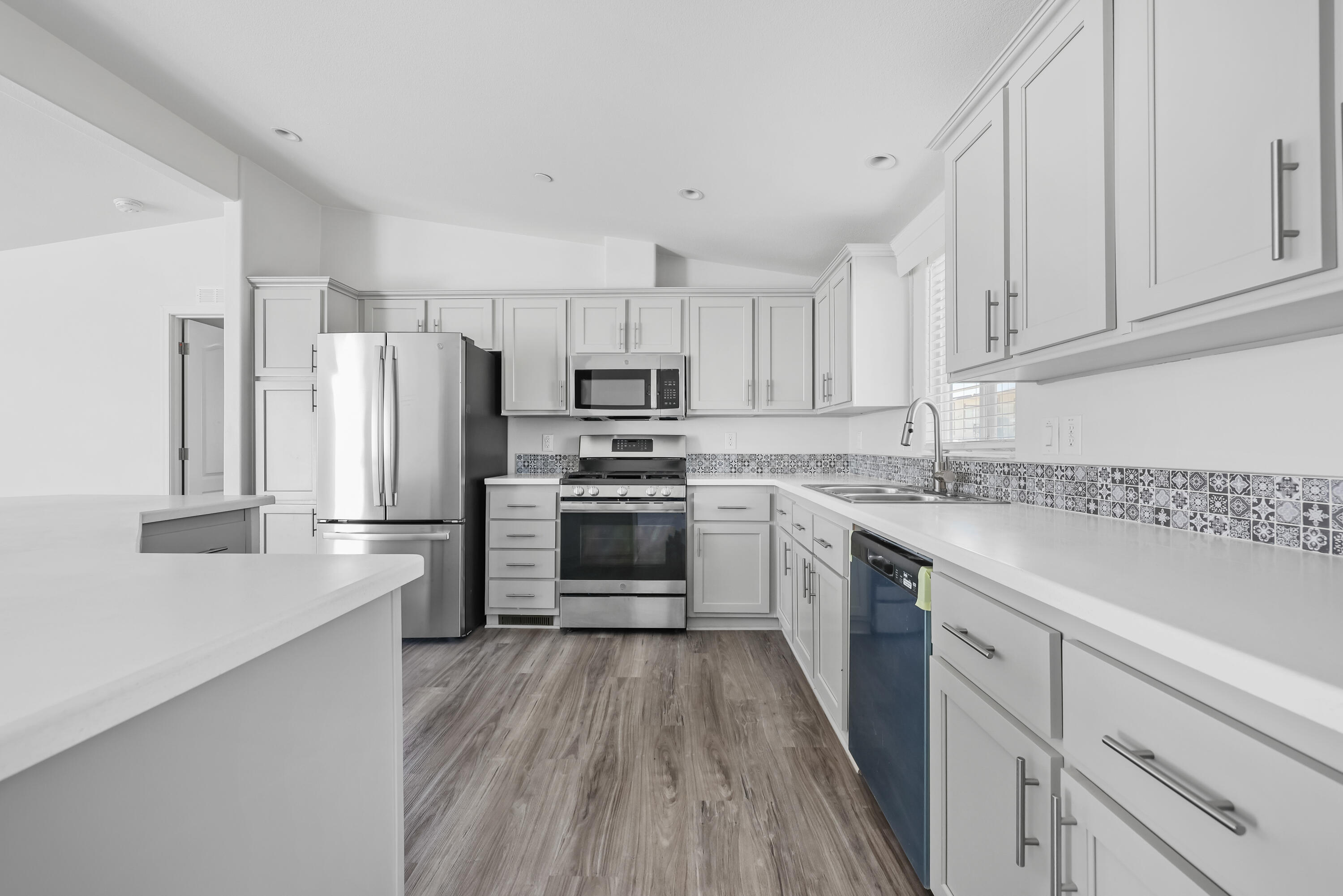 a kitchen with white cabinets and stainless steel appliances