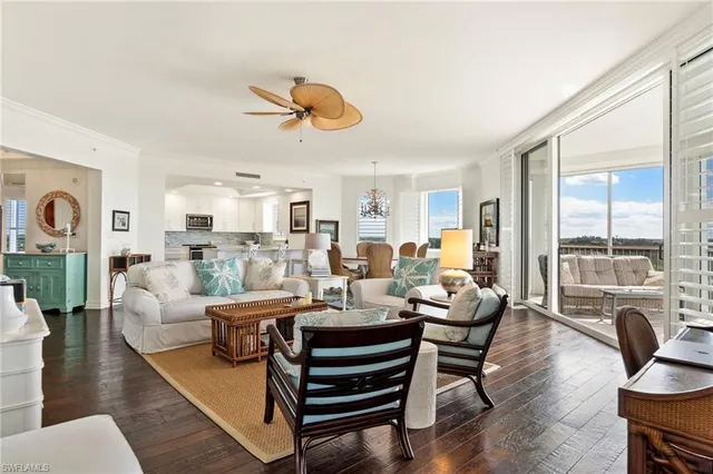 a living room with furniture kitchen view and large windows