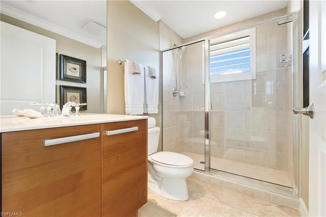 a bathroom with a shower sink vanity mirror and toilet
