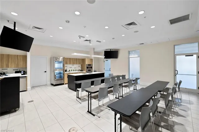 a living room with furniture a flat screen tv and kitchen view