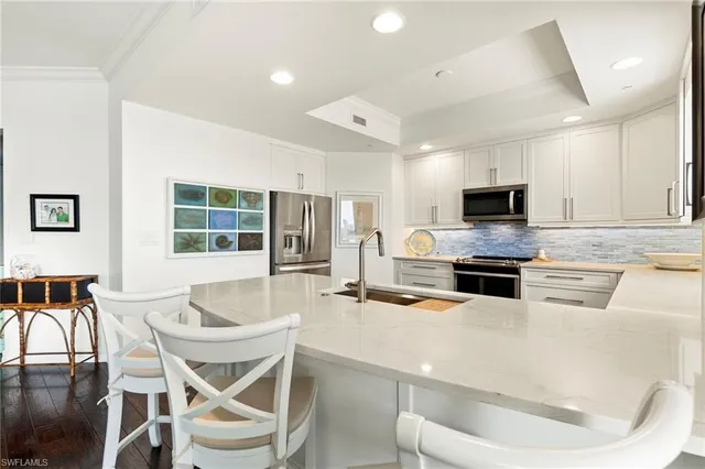 a kitchen with stainless steel appliances kitchen island granite countertop a stove a table and chairs in it