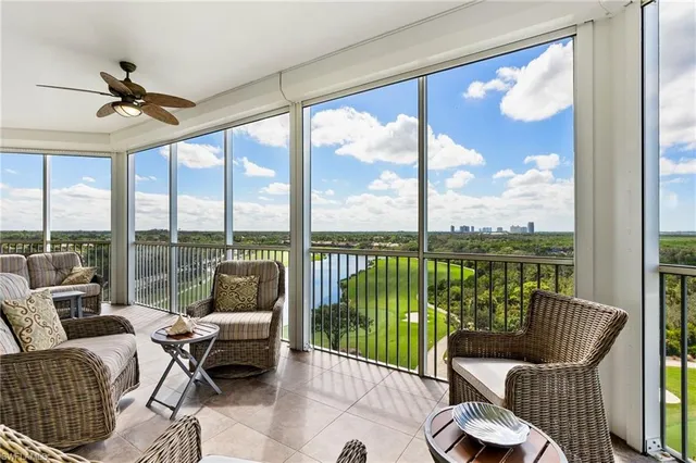 a living room with furniture and floor to ceiling windows