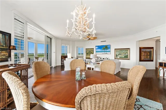 a living room with furniture a chandelier and a dining table