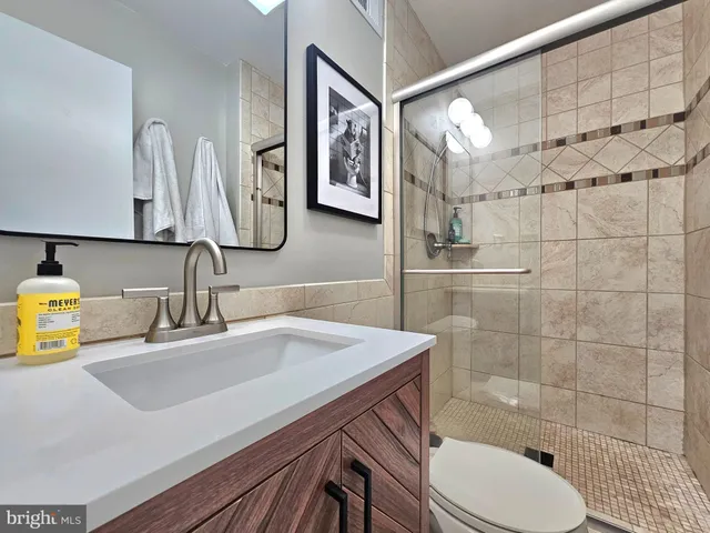 a bathroom with a sink mirror toilet and shower