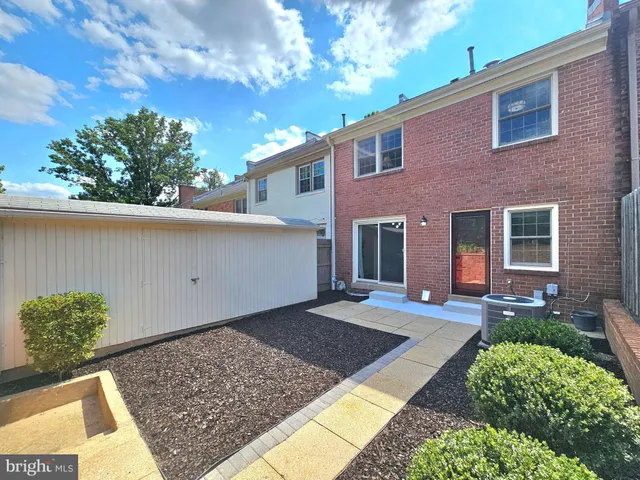 a view of a house with a yard and potted plants