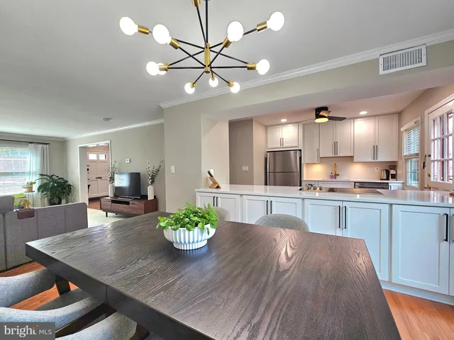 a view of a dining room with furniture a chandelier and wooden floor