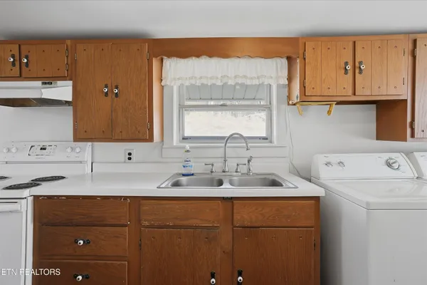 a kitchen with a sink a stove a refrigerator and cabinets