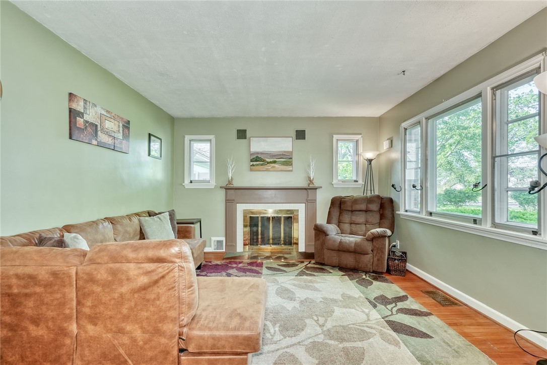 606 Bay Road Webster, NY 14580 - Photo 3 of 49 Family room with hardwood floors, woodburning fire