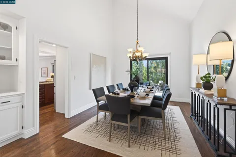 a view of a dining room with furniture a chandelier and wooden floor