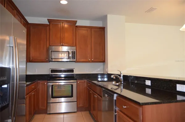 a kitchen with stainless steel appliances a stove a microwave and a refrigerator