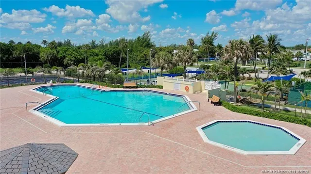 a view of a swimming pool with a yard and trees