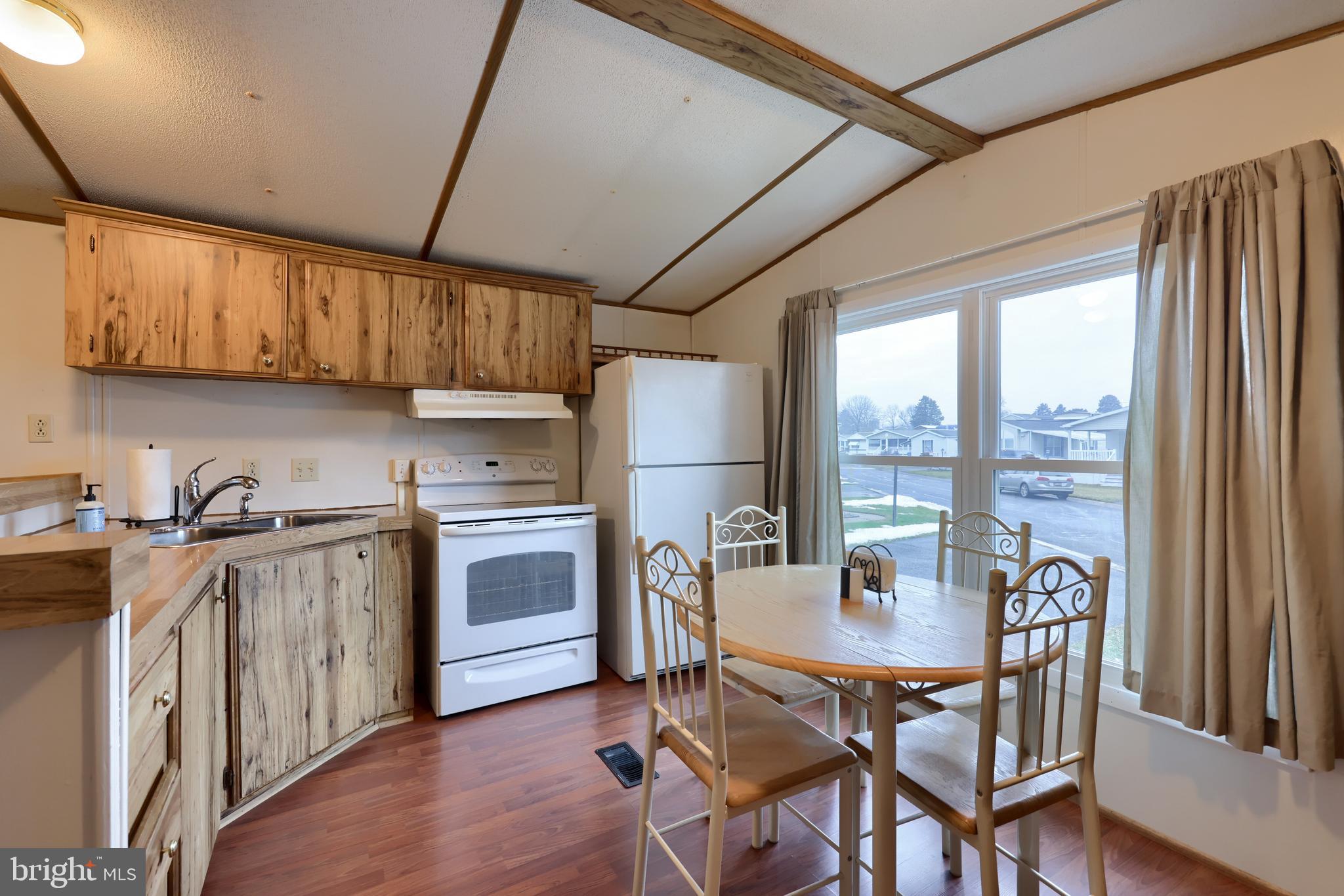 123 Ridgewood Manor Manheim, PA 17545 - Photo 6 of 25 a kitchen with a table chairs refrigerator and cabinets