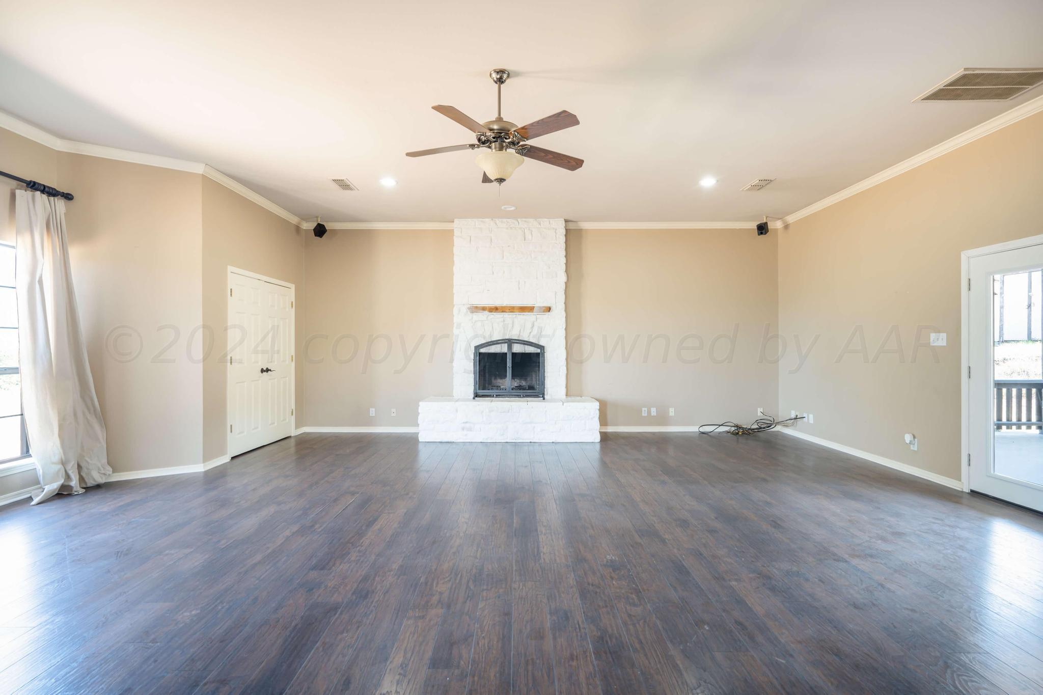 11601 East View Drive Amarillo, TX 79124 - Photo 5 of 20 an empty room with wooden floor fireplace and windows