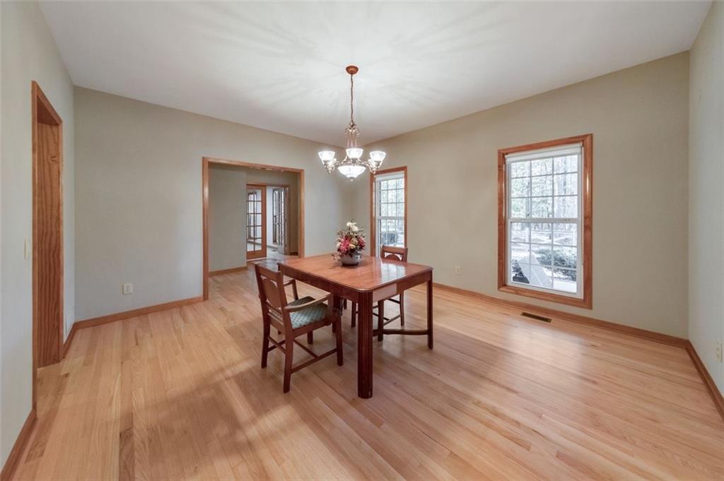 5940 Old Stilesboro Road Northwest Acworth, GA 30101 - Photo 18 of 61 a dining room with wooden floor a chandelier a wooden table and chairs
