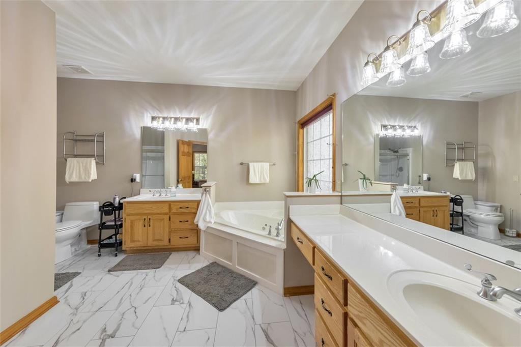 5940 Old Stilesboro Road Northwest Acworth, GA 30101 - Photo 5 of 61 a spacious bathroom with a granite countertop tub sink and mirror