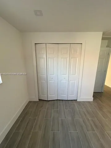 an empty room with wooden door and cabinet