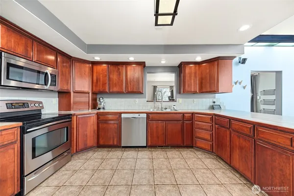 a kitchen with stainless steel appliances granite countertop a stove microwave and sink