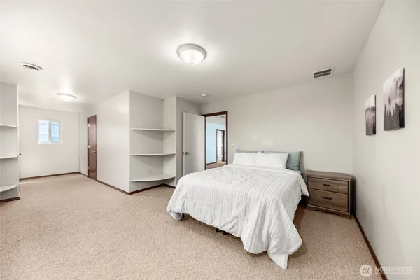a spacious bedroom with a bed and a cabinets