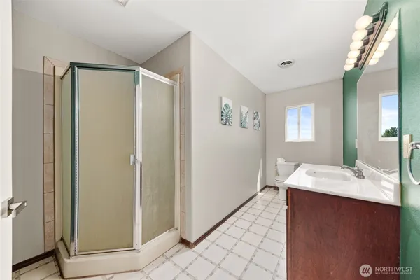 a bathroom with a sink mirror and shower