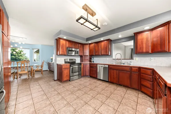 a kitchen with stainless steel appliances granite countertop a stove granite counter tops and a view of living room