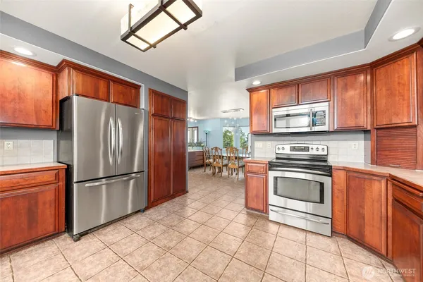 a kitchen with stainless steel appliances granite countertop a refrigerator sink and stove