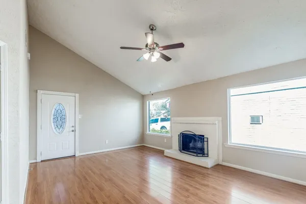 a view of an empty room with a fireplace and a window