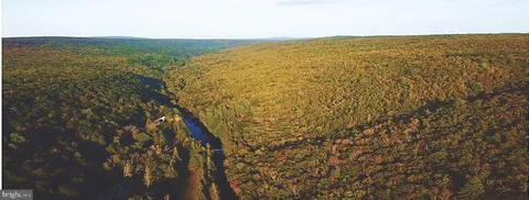 a bedroom with a bed and large windows