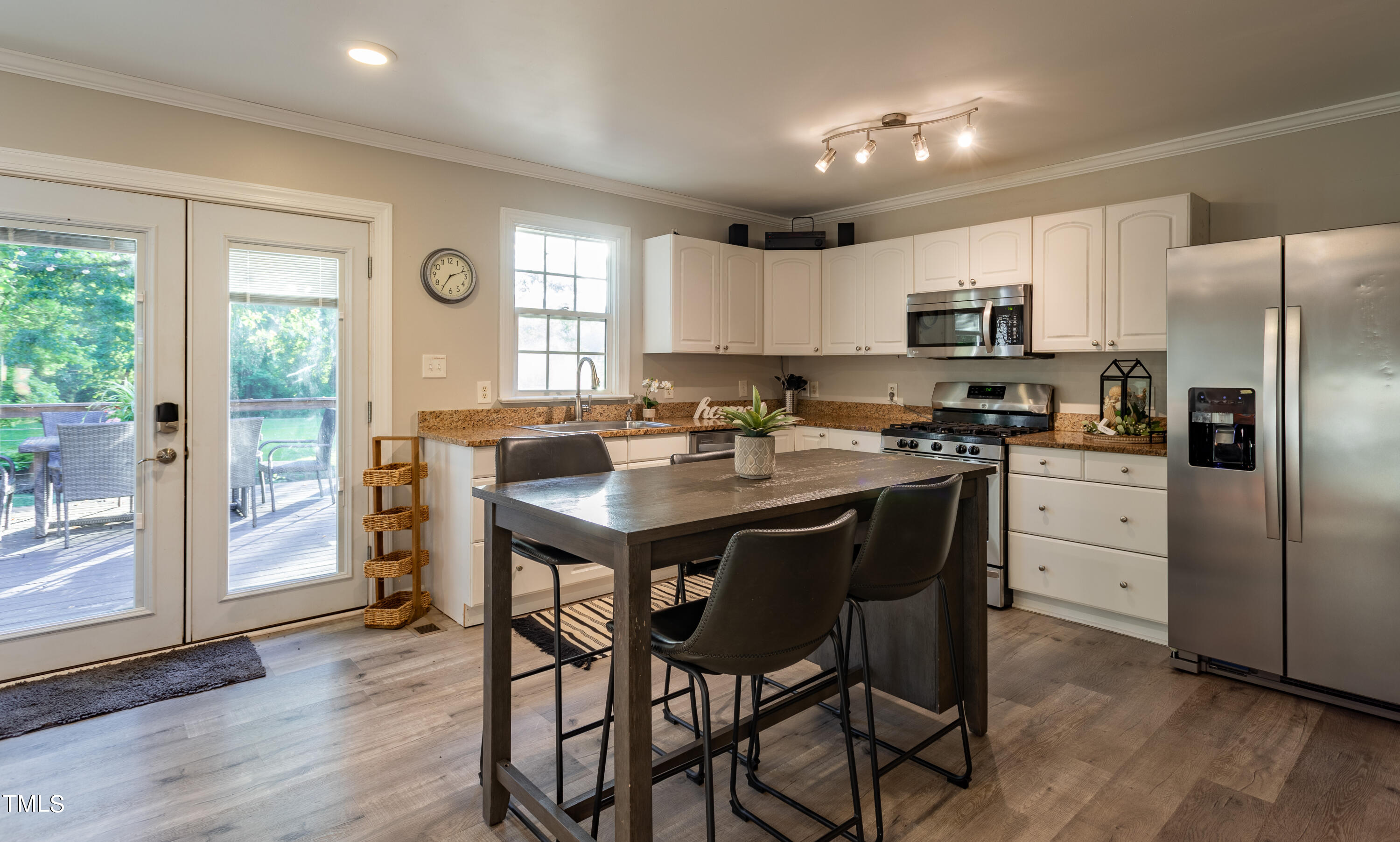 1304 West Garner Road Garner, NC 27529 - Photo 7 of 36 a kitchen with stainless steel appliances granite countertop a refrigerator a stove a sink dishwasher a dining table and chairs with wooden floor