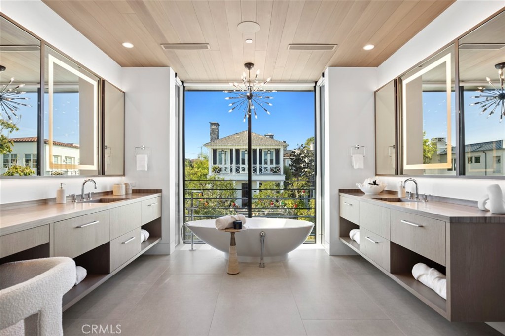 304 Poppy Avenue Corona del Mar, CA 92625 - Photo 19 of 35 a large bathroom with a double vanity sink a large mirror and a bathtub