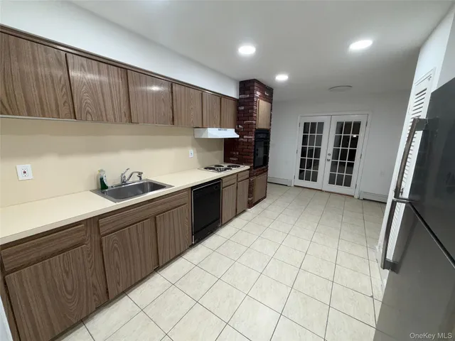 a kitchen with stainless steel appliances granite countertop a sink refrigerator and cabinets