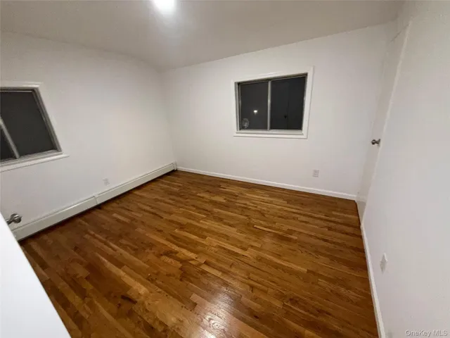 a view of a room with wooden floor and a ceiling fan