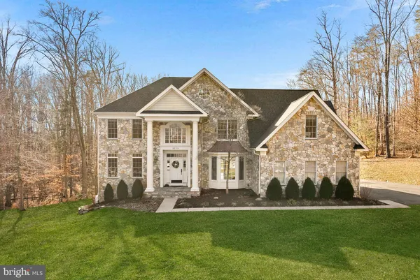 a front view of a house with a yard and trees