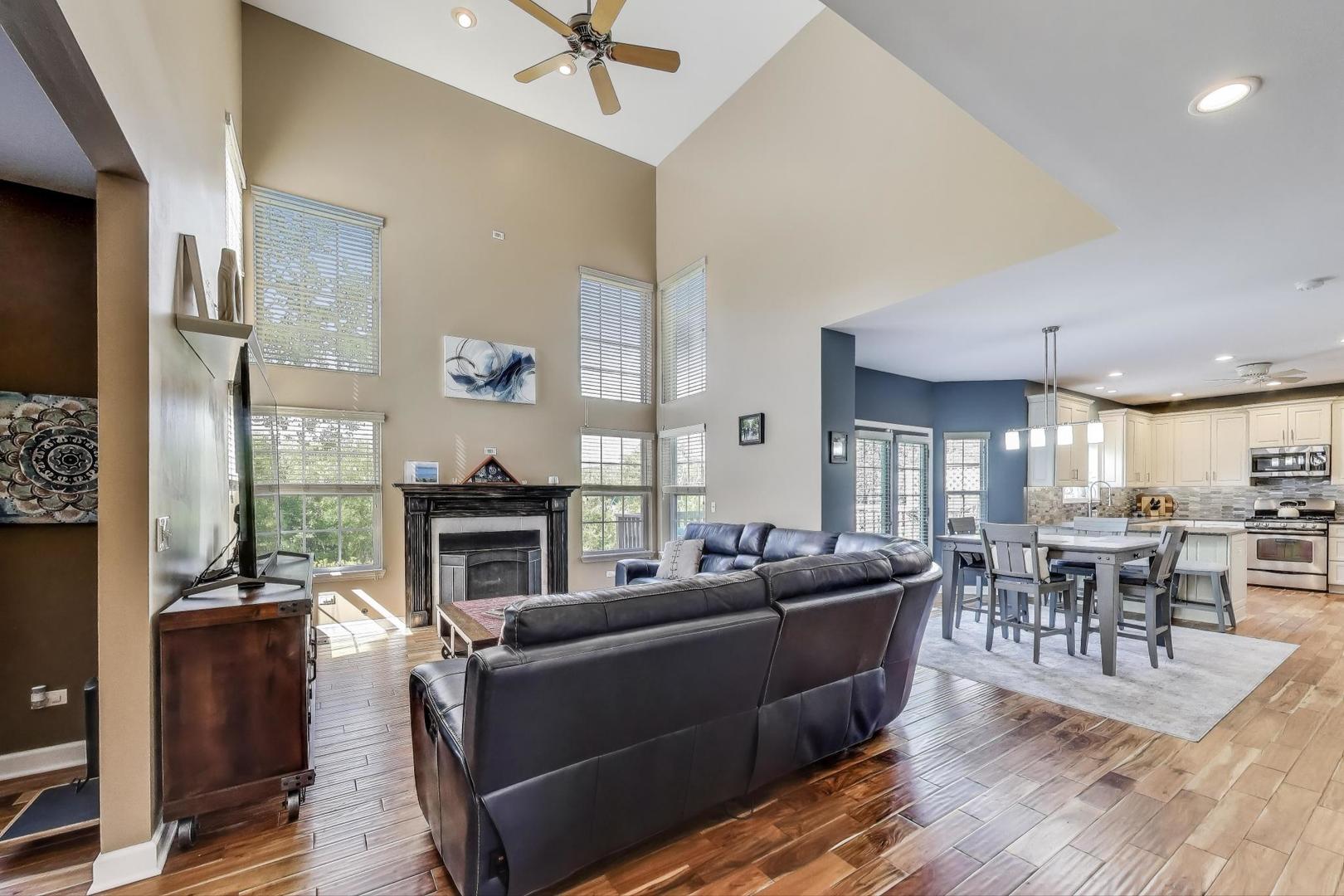 17119 West Prairieview Lane Gurnee, IL 60031 - Photo 12 of 40 a living room with furniture a fireplace and a dining table with wooden floor