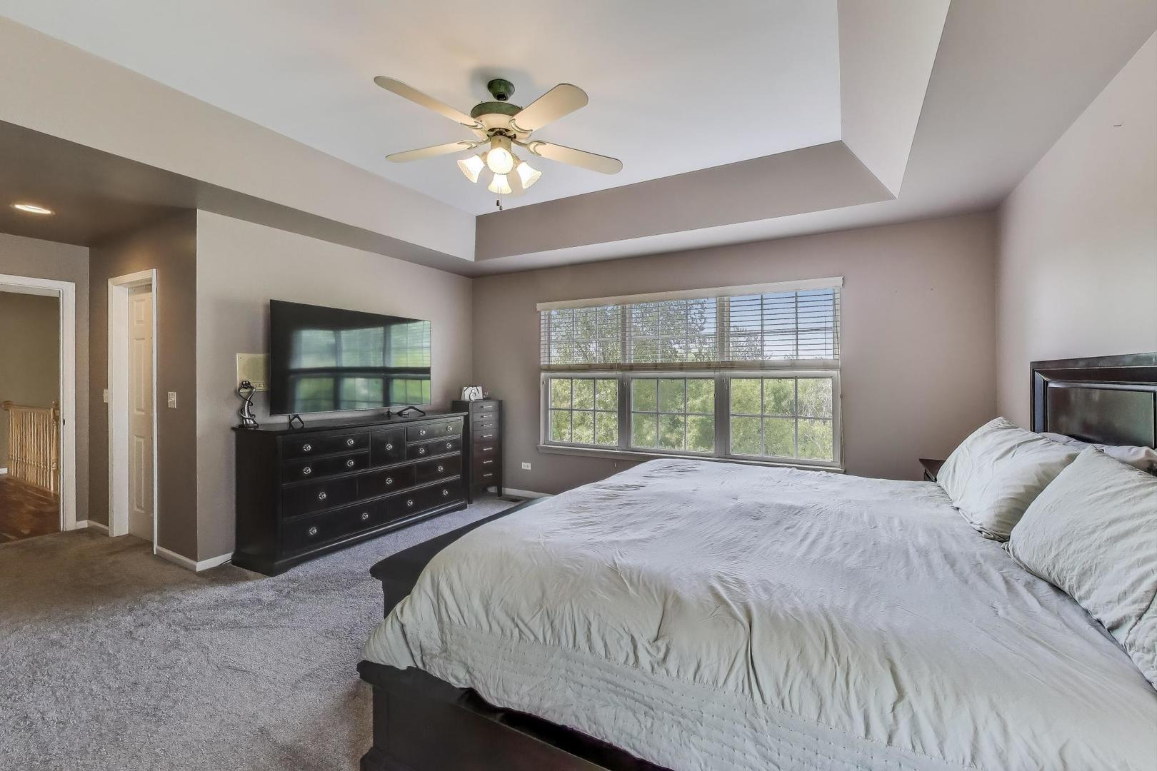 17119 West Prairieview Lane Gurnee, IL 60031 - Photo 18 of 40 a bedroom with a large bed and a flat tv screen on dresser