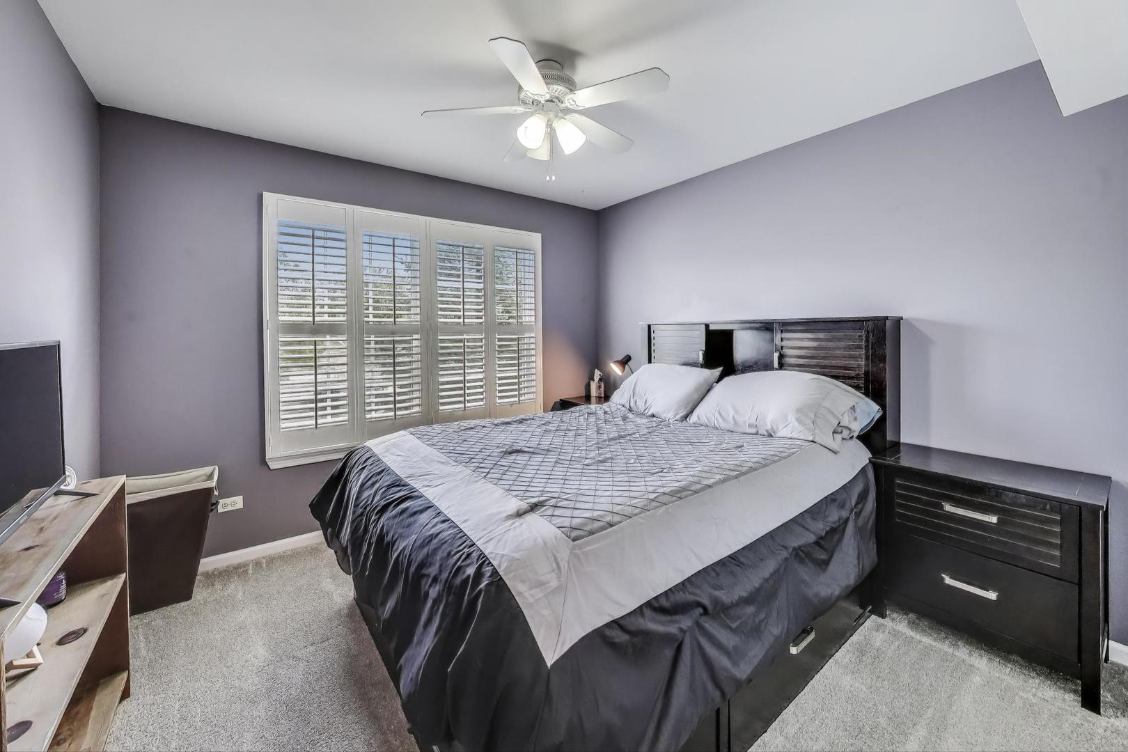 17119 West Prairieview Lane Gurnee, IL 60031 - Photo 24 of 40 a bedroom with a bed and a chandelier