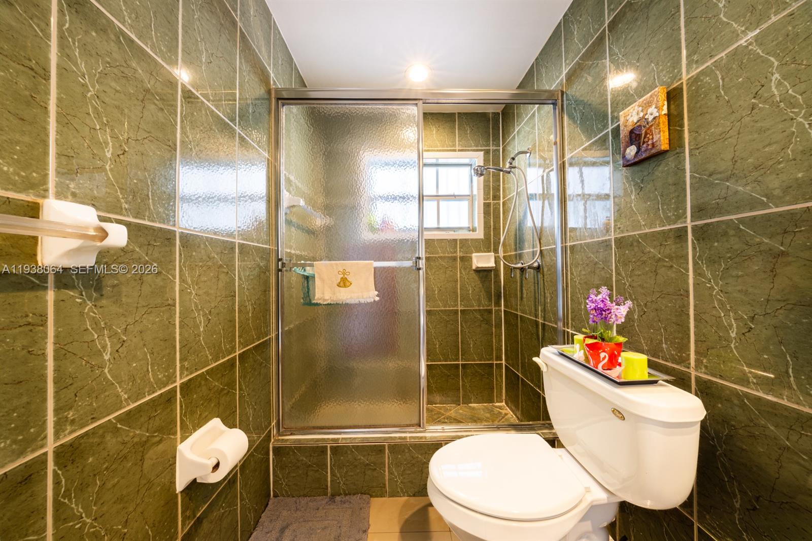 1937 Southwest 57th Court Miami, FL 33155 - Photo 17 of 23 a white toilet and shower in a bathroom