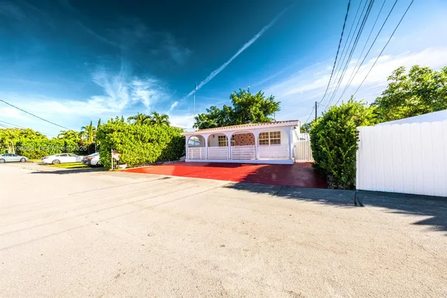 a view of a house with a yard and potted plants