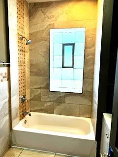 a bathroom with a bathtub and shower